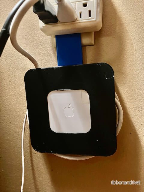 MacBook-laddarhållare och kabelorganisatör för vägguttag