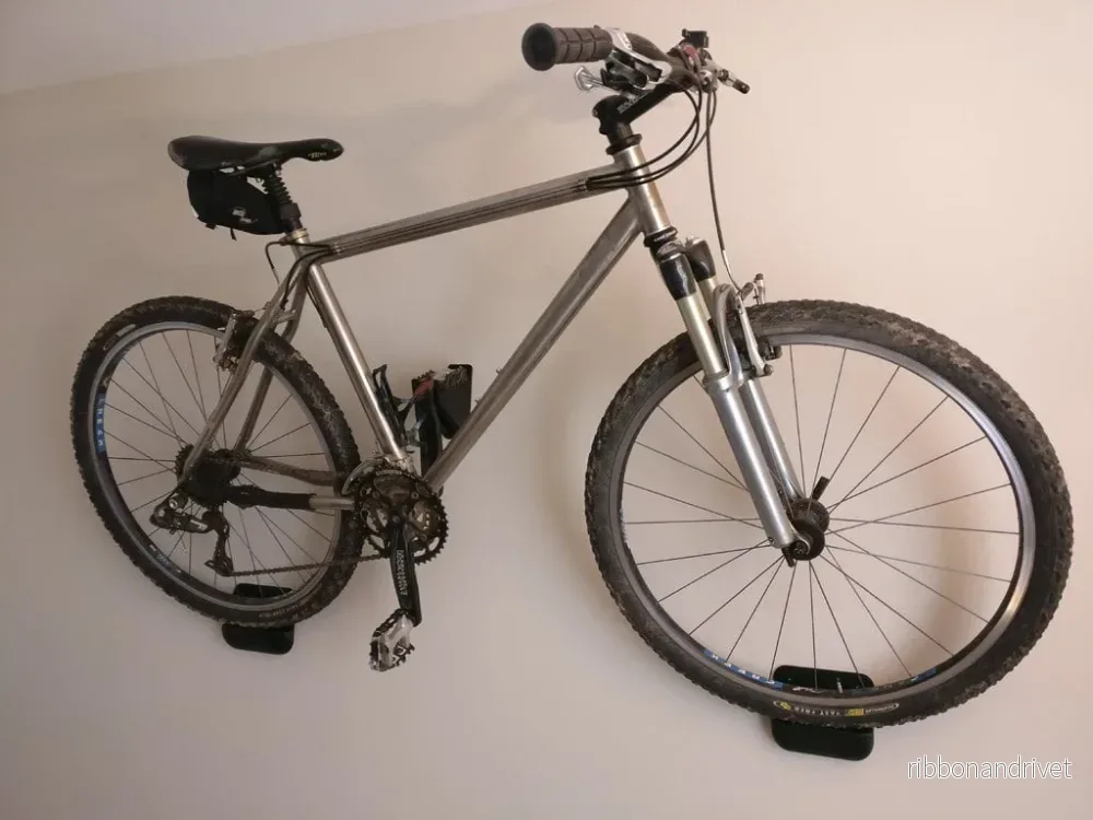 Platsbesparande väggfäste för cykel med pedalhållare