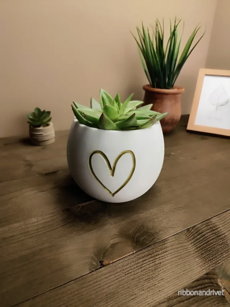 Söt liten blomkruka med hjärtformat relief