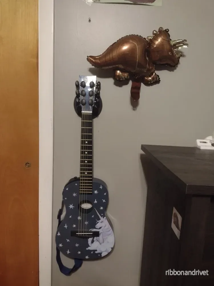 T-rex gitarrväggfäste med dinosauriedesign